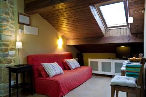 a living room with a red couch and a window at Apartamentos Playa Galizano in Galizano