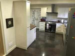 a kitchen with white cabinets and a black stove at Sage House in Northampton