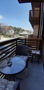 a patio with a table and chairs on a balcony at Apartman Lukić in Zlatibor