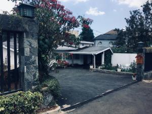 a driveway in front of a house with a garage at Little England Bungalow in Nuwara Eliya