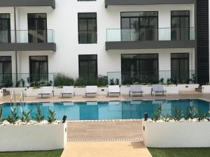 a hotel with a swimming pool in front of a building at A007 Embassy Gardens Studio Apartm in Accra