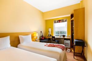 a hotel room with two beds and a desk at Ibis Al Rigga in Dubai +37 photos