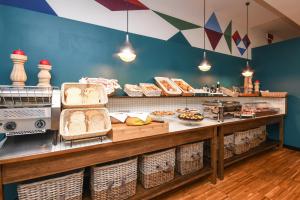 a bakery with a counter with bread and other foods at Hotel City in Desenzano del Garda +74 photos