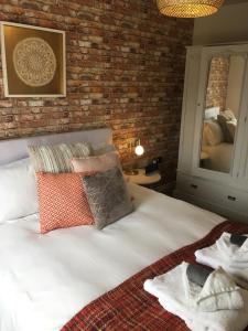 - une chambre avec un lit blanc et un mur en briques dans l'établissement River View, à York