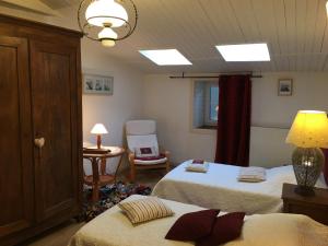 1 dormitorio con 2 camas, mesa y silla en Chambres d'Hôtes Le Logis du Port Paradis, en Nieulle-sur-Seudre