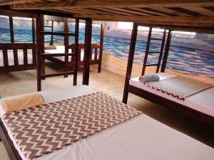 two beds in a room with a view of the ocean at Soul Breeze Backpackers Diani in Diani Beach