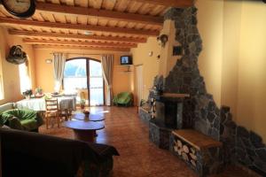 a living room with a stone fireplace and a table at Penzión Ľadová in Stratená