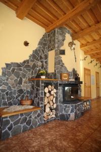 a stone fireplace in a room with a stove at Penzión Ľadová in Stratená