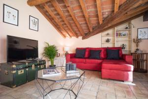 ボローニャにあるAltabella Rooftopの赤いソファとテーブルのあるリビングルーム