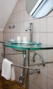 a bathroom with a glass sink and a mirror at Hotel zur Post in Arnsberg