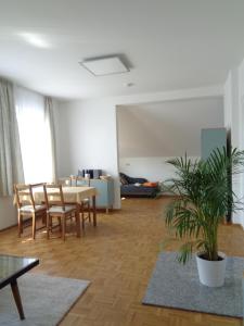 - un salon avec une table, des chaises et une plante dans l'établissement Leipzig-Südwest, à Leipzig