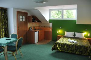 a bedroom with a bed and a table and a kitchen at Willa Stenia Center Apartamenty in Wisła