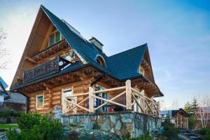 une cabane en rondins avec un toit en gambrel dans l'établissement Kwiat Śniegu DeLuxe Koło Gubałówki, à Nowe Bystre