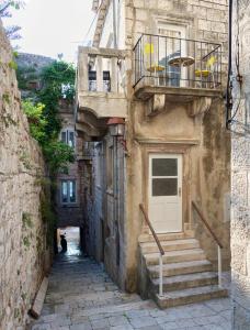 an alley with stairs and a door in a building at White House Apartments in Korčula
