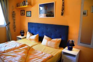 a bedroom with a bed with a blue headboard and two lamps at Can Tapsy in Tossa de Mar +34 photos