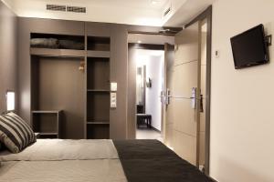 une chambre avec un lit et une télévision à écran plat dans l'établissement Dalia Ramblas, à Barcelone