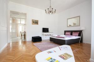 ブダペストにあるChic & Charm Apartmentのリビングルーム(ベッド1台、テーブル付)