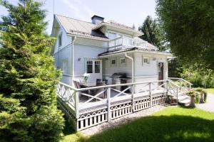 Casa blanca grande con una gran terraza de madera en Villa Satulinna en Kotka