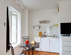 White House Apartments في كورتْشولا: مطبخ أبيض مع طاولة ومغسلة