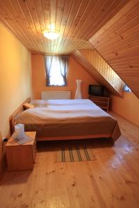 a bedroom with a large bed and a window at Penzión Ľadová in Stratená