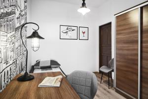 a room with a table and a chair and a lamp at Prestige Apartments 7 in Wrocław