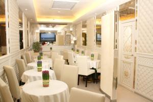 un ristorante con tavoli e sedie bianche di Hotel Valle a Roma