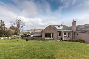 a house with a car parked in a yard at The Sheiling B&B - NC 500 in Melvich