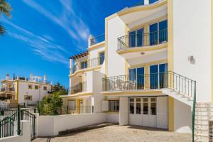 - un bâtiment blanc avec balcon et ciel bleu dans l'établissement Villas Alto da Ria, à Alvor