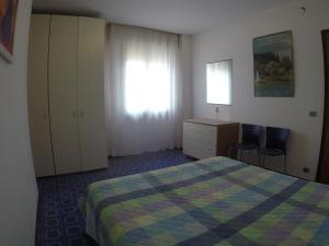 una camera da letto con un letto, una scrivania e una finestra di Condominio Commerciale a Caorle