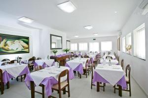 een eetkamer met paarse tafels en stoelen bij Hotel Blues in Cervia