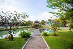 una pasarela que conduce a un estanque en un parque en Jintana Resort, en Buriram