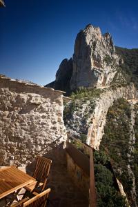 un edificio de piedra con una montaña en el fondo en Casa Jou, en Abella de la Conca