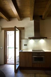a kitchen with a stove top oven next to a door at Casa Jou in Abella de la Conca