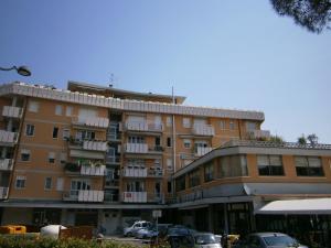 un grande edificio con auto parcheggiate di fronte di Condominio Commerciale a Caorle