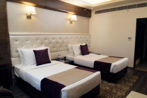 two beds in a hotel room with two beds at Zone by The Park, Jammu in Jammu