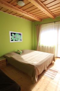 a bedroom with a large bed with a green wall at Penzión Ľadová in Stratená