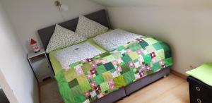 a bedroom with a bed with a quilt on it at Ferienwohnung Voelkel mit Dachterrasse in Trier