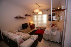 a living room with two beds and a television at Pine-Tree Apt w/ Private Garden 50 m from the Sea in Golem