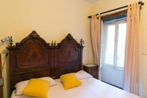 - une chambre avec un grand lit en bois et des oreillers jaunes dans l'établissement Villa La Casa dell'Isola, à Orta San Giulio