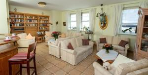 a living room with white furniture and a dog laying on a table at Hotel Lessing in Düsseldorf