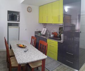 a kitchen with a table and yellow cabinets at Apartamento Balsa in Viseu