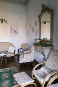 - un salon avec des chaises et un miroir dans l'établissement Villa La Casa dell'Isola, à Orta San Giulio