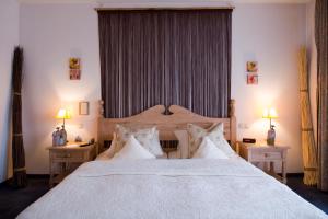 a bedroom with a large white bed with two tables at Hotel Lessing in Düsseldorf