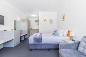 - une chambre avec un lit et un canapé dans l'établissement Hi 5 Glenelg Studio Apartment, à Glenelg