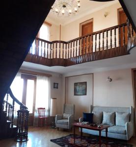 a living room with a couch and a staircase at Omsi House in Tʼelavi