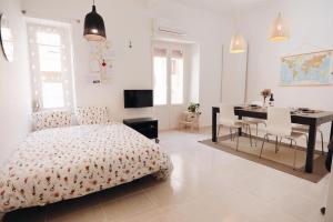 1 dormitorio con 1 cama, mesa y sillas en Amparito Apartment - Casc Antic, en Tarragona