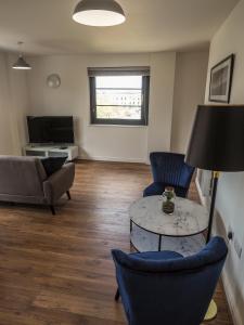 a living room with a couch and a table and chairs at Stylish Spacious Apartment with Free Parking in Farnborough