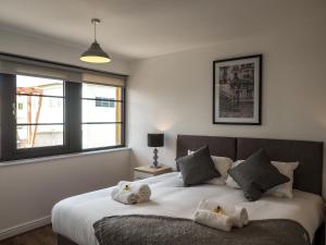 a bedroom with a bed with stuffed animals on it at Stylish Spacious Apartment with Free Parking in Farnborough
