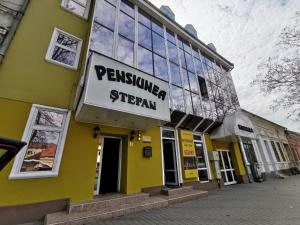 a yellow building with a sign that reads permission system at Pensiunea Stefan in Bistriţa