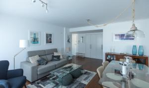uma sala de estar com um sofá e uma mesa em Charming Apartment with Balcony & Pool em Lisboa